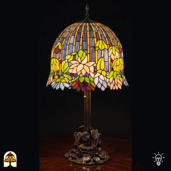Verlichte Tiffany tafellamp Pond Lilia ⌀40 cm op zwarte achtergrond – waterlelies in crème en groen glas-in-lood kap, bronzen voet met waterlelieblad motief
