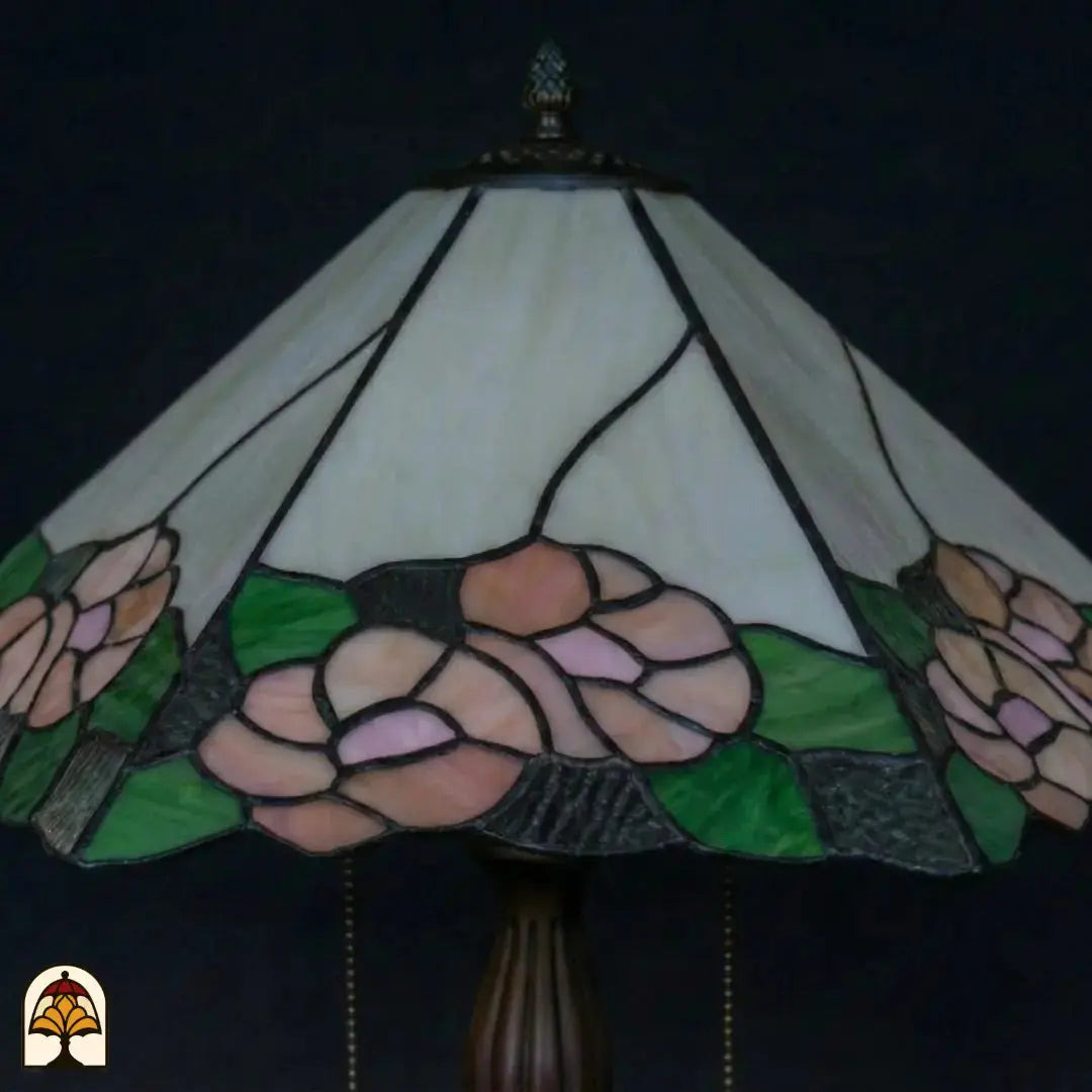 Close-up onverlichte kap Tiffany tafellamp Alba Sereno, roze rozen en groene bladeren, grijze geribbelde randpanelen
