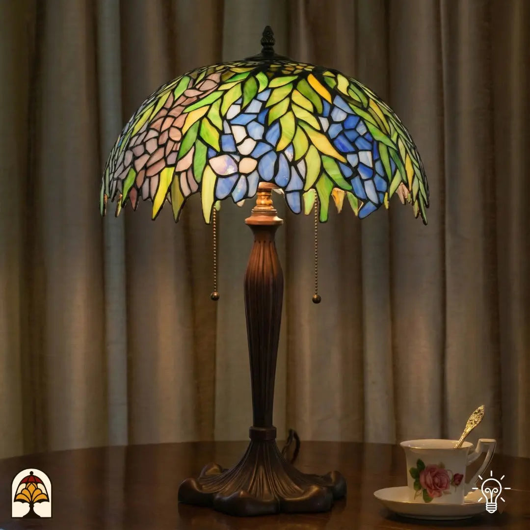 Lifestyle — verlichte Tiffany tafellamp op tafel voor beige gordijnen, theekopje met schotel ernaast