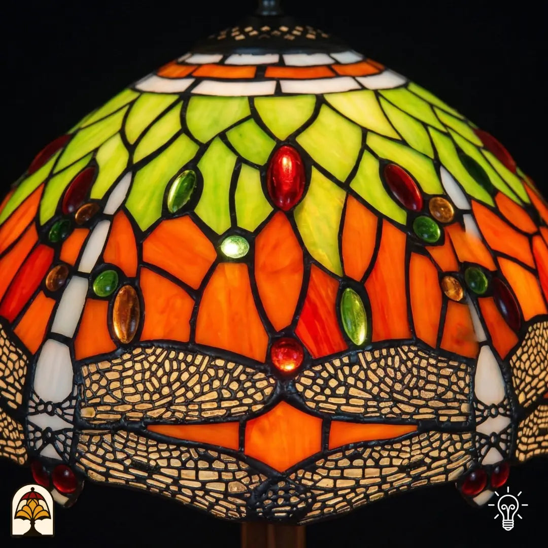 Close-up verlichte kap Libellula Azul ⌀30, oranje glas-in-lood panelen met geel-groene bladmotieven, rode en groene ovale juwelen en libellenfries onderaan