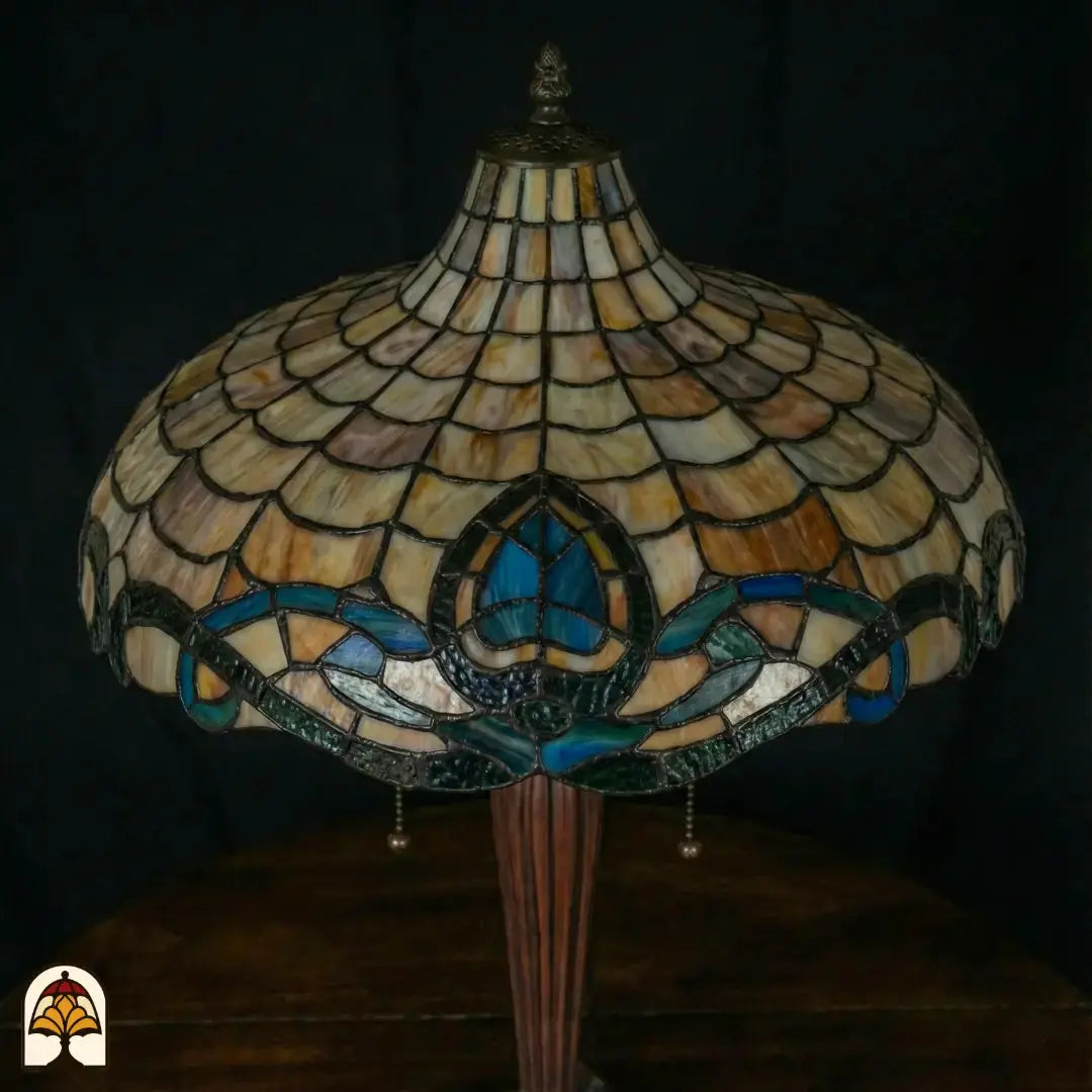 Close-up onverlichte Tiffany kap andere hoek — beige/amber schubpatroon, turquoise en blauwe lotusmotief rand