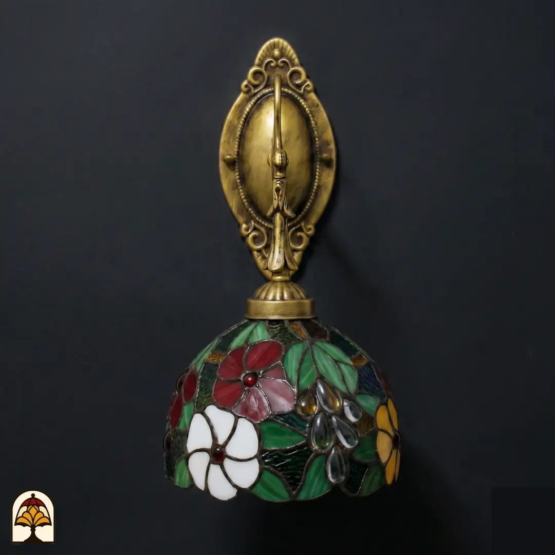 Onverlichte Tiffany wandlamp Floral Garden frontaal, florale glas-in-lood kap met rode, witte en gele bloemen en groene bladeren op bronzen arm