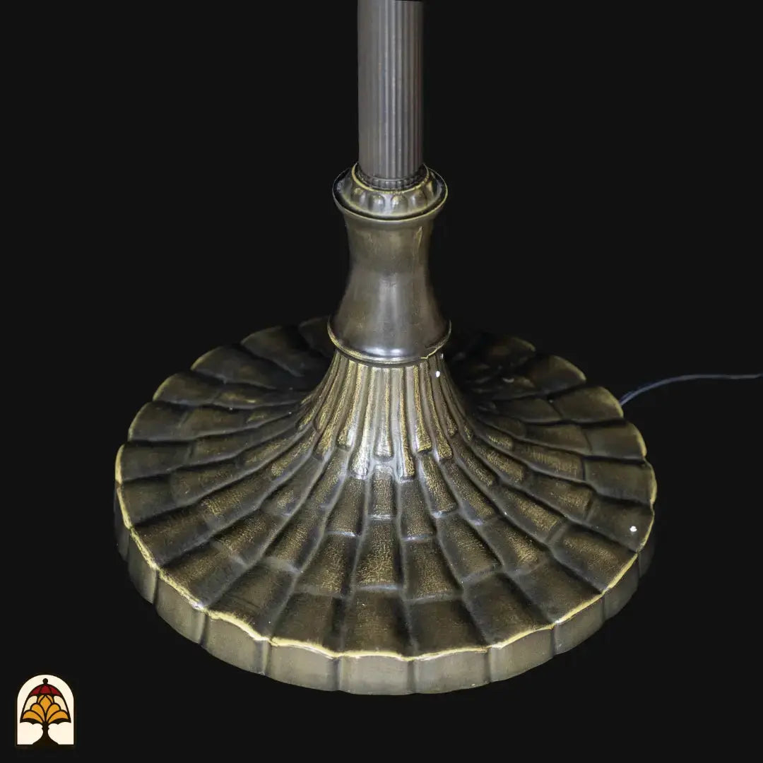 Close-up voet Tiffany vloerlamp Libellula Aurea — brede ronde voet in geoxideerd brons met decoratief ribbelpatroon, aansluitsnoer zichtbaar
