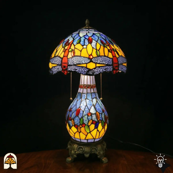 Verlichte Tiffany tafellamp Libellula Azurea ⌀30 cm op zwarte achtergrond – azuurblauwe koepelkap met libellenmotief, bronzen kolomvoet