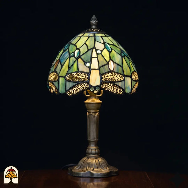 Verlichte Tiffany tafellamp Libellula Celeste ⌀20 cm op zwarte achtergrond – lichtblauwe koepelkap met libellenmotief, bronzen kolomvoet