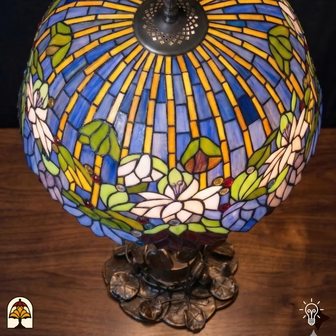 Bovenaanzicht verlichte koepelkap Tiffany tafellamp Pond Lilia, blauwe en gele verticale strepen, witte waterlelies en groene bladeren, centrale bronzen fitting