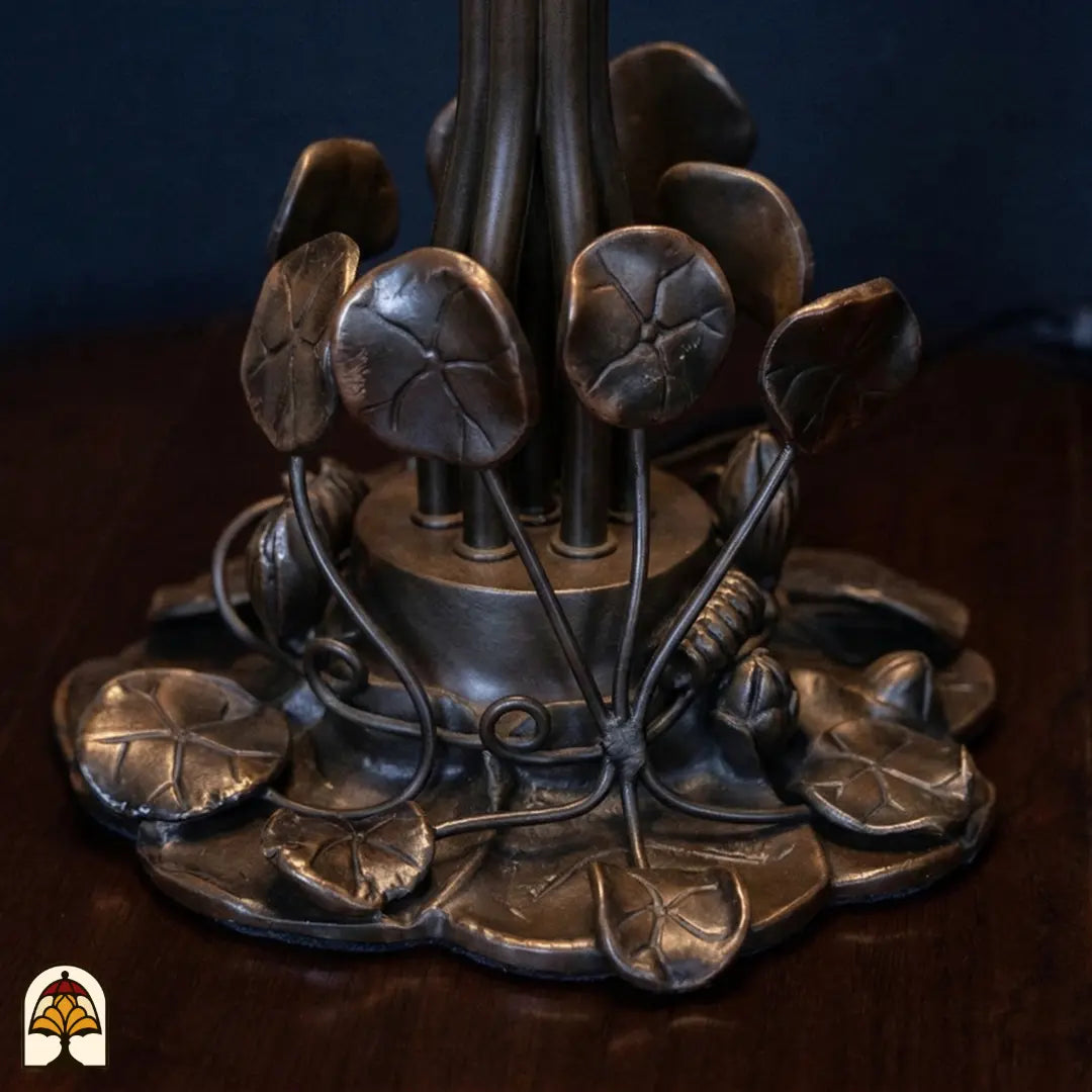 Close-up bronzen voet Tiffany tafellamp Pond Lilia – waterlelieblad motief en sierlijke rankwerk