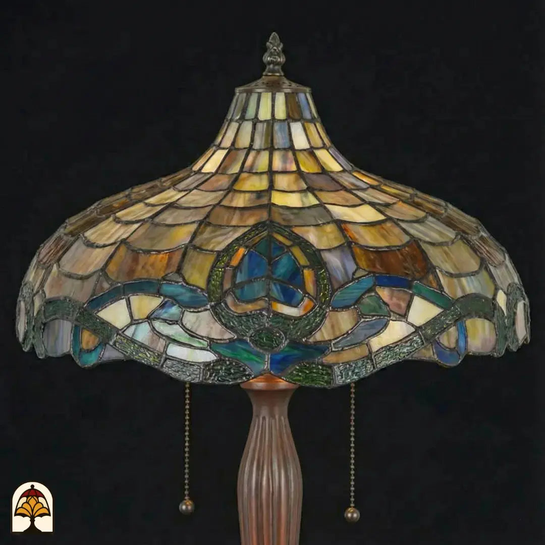 Close-up onverlichte Tiffany kap — amber/beige schubpatroon, turquoise lotusmotief, blauwe en groene Art Nouveau rand, trekschakelaars