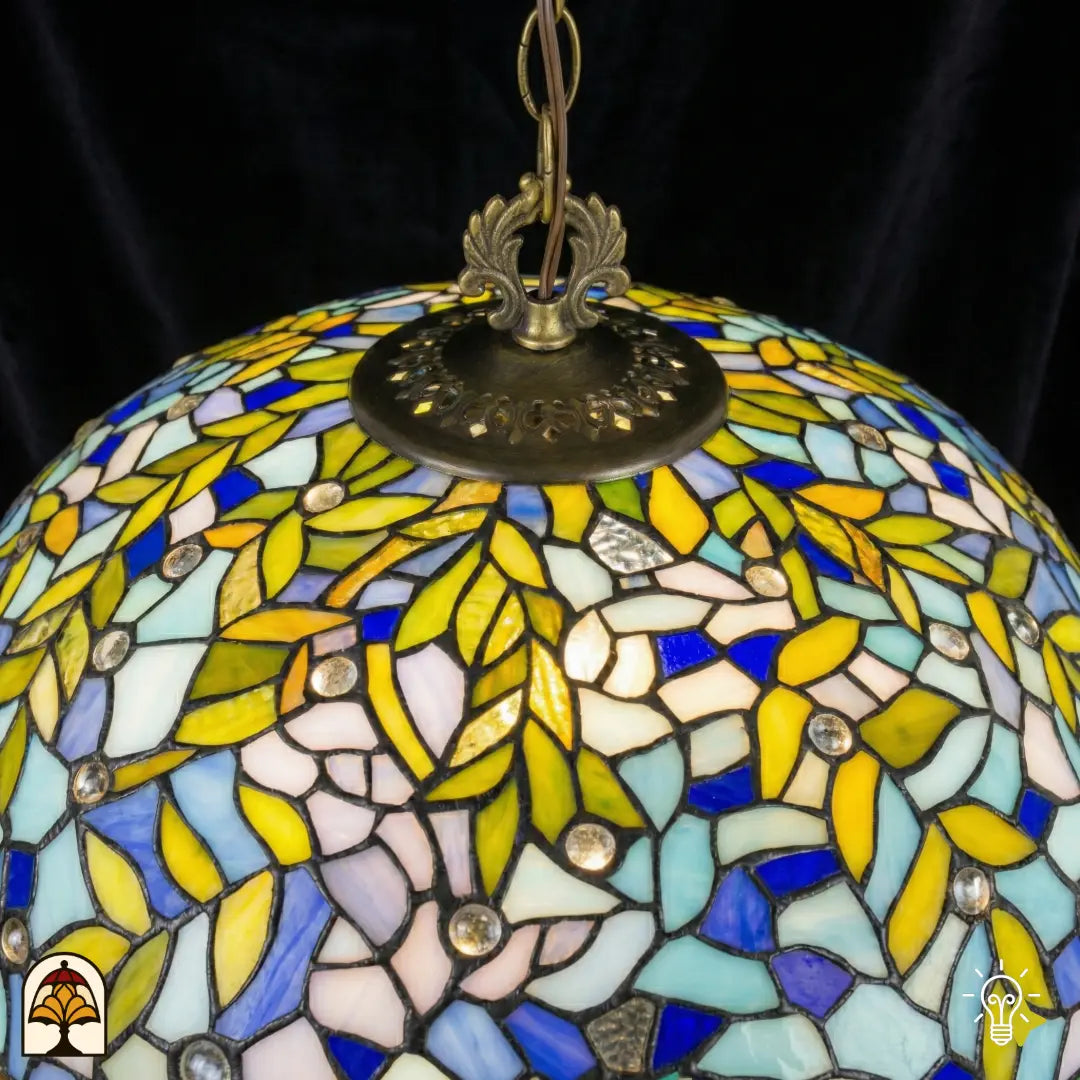 Close-up onverlichte kap Drizzle Bleu ⌀50 van bovenaf, blauwe, turquoise en witte glas-in-lood panelen met gele bladmotieven, ronde kristalaccenten, bronzen centrale fitting