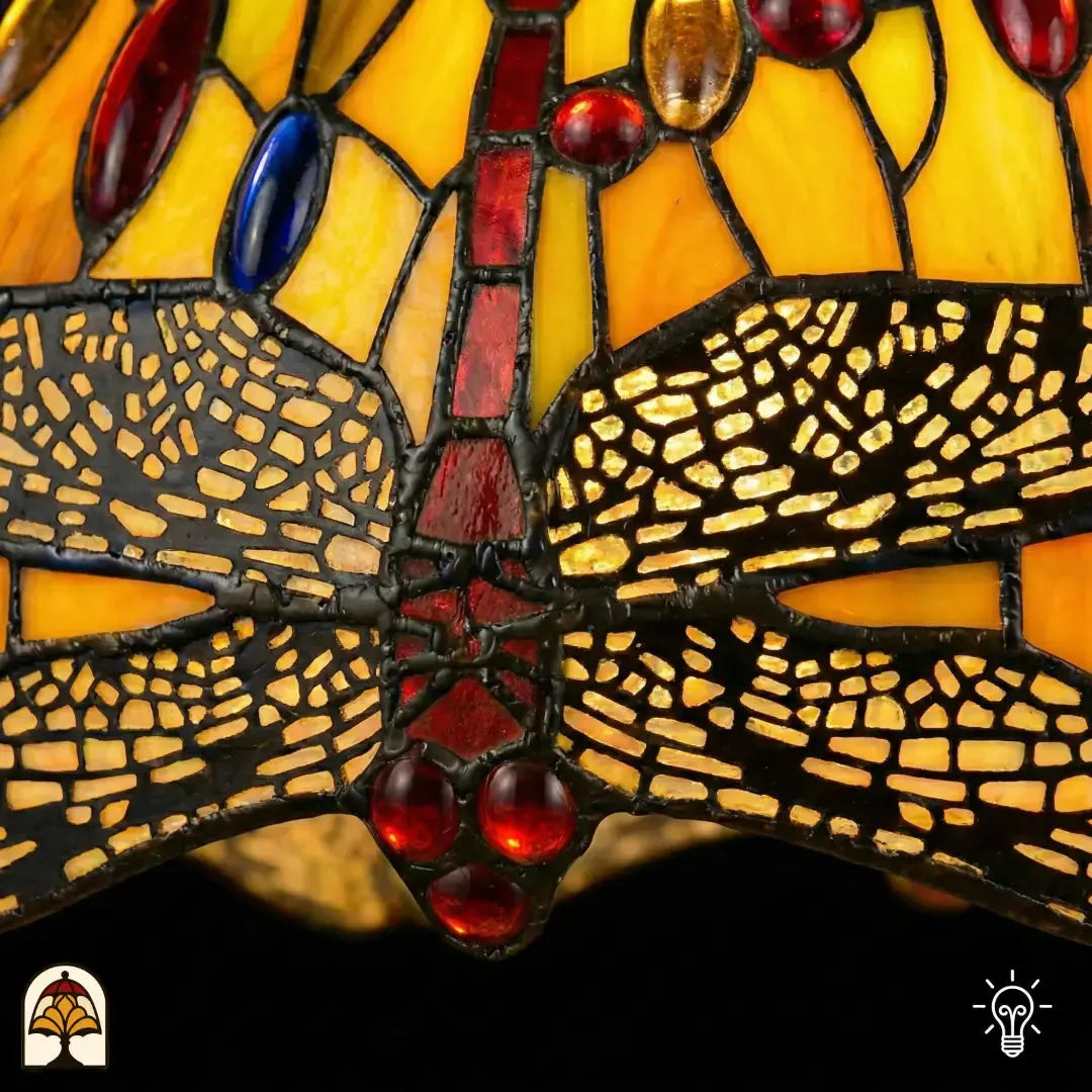 Close-up verlichte libellenmotief langs rand kap Libellula Aurelia ⌀50, amber-gele panelen, grijze libellenvleugels met rode juwelen