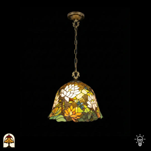 Tiffany lamp hanglamp verlicht, klokvormige glas-in-lood kap met witte lotusbloemen, oranje-gele lotusbloemen, groene waterleliebladen en een libelle op bruinamberen achtergrond, gekartelde rand, opgehangen aan bronzen ketting met sierlijke plafondrozet