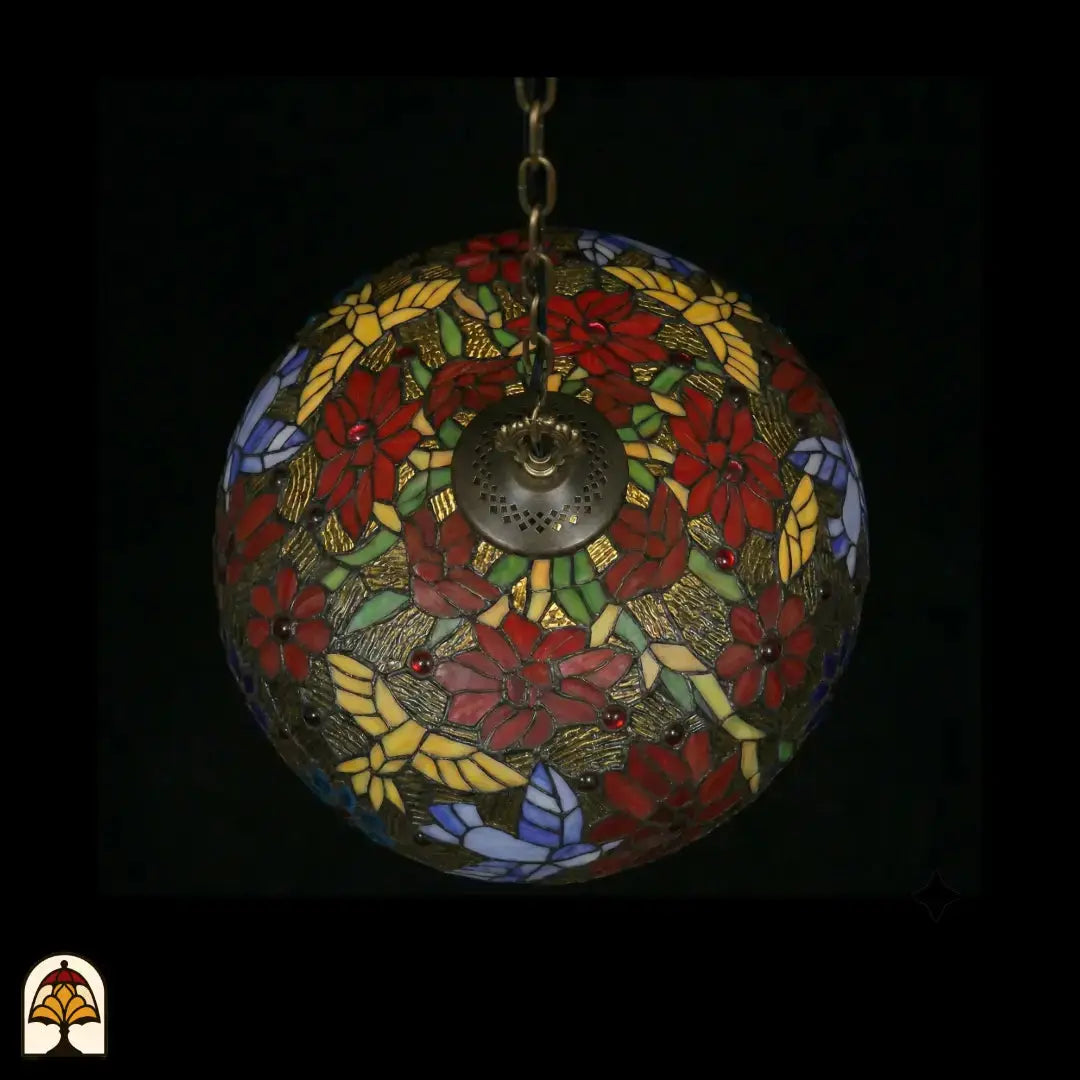Onderkant bovenaanzicht van tiffany lamp hanglamp onverlicht, koepel met symmetrisch patroon van rode poinsettia-bloemen, gele bladpanelen, groene bladeren, lavendel vlinders en blauwe bloemaccenten, centrale bronzen ventilatieplaat zichtbaar