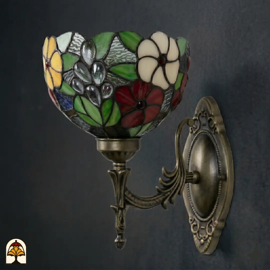 Onverlichte Tiffany wandlamp Floral Garden van opzij, kap met groene bladeren, rode, witte en gele bloemen en grijze druppels in glas-in-lood