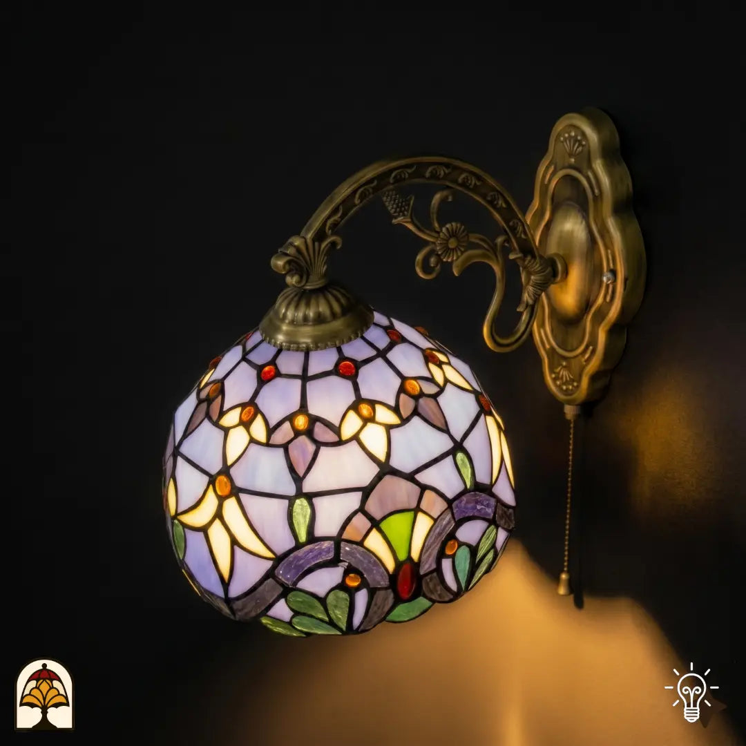 Zijaanzicht verlichte Tiffany wandlamp Royal Mosaic met bolronde lavendelblauwe kap en bronzen arm met druiventros- en bloemmotieven