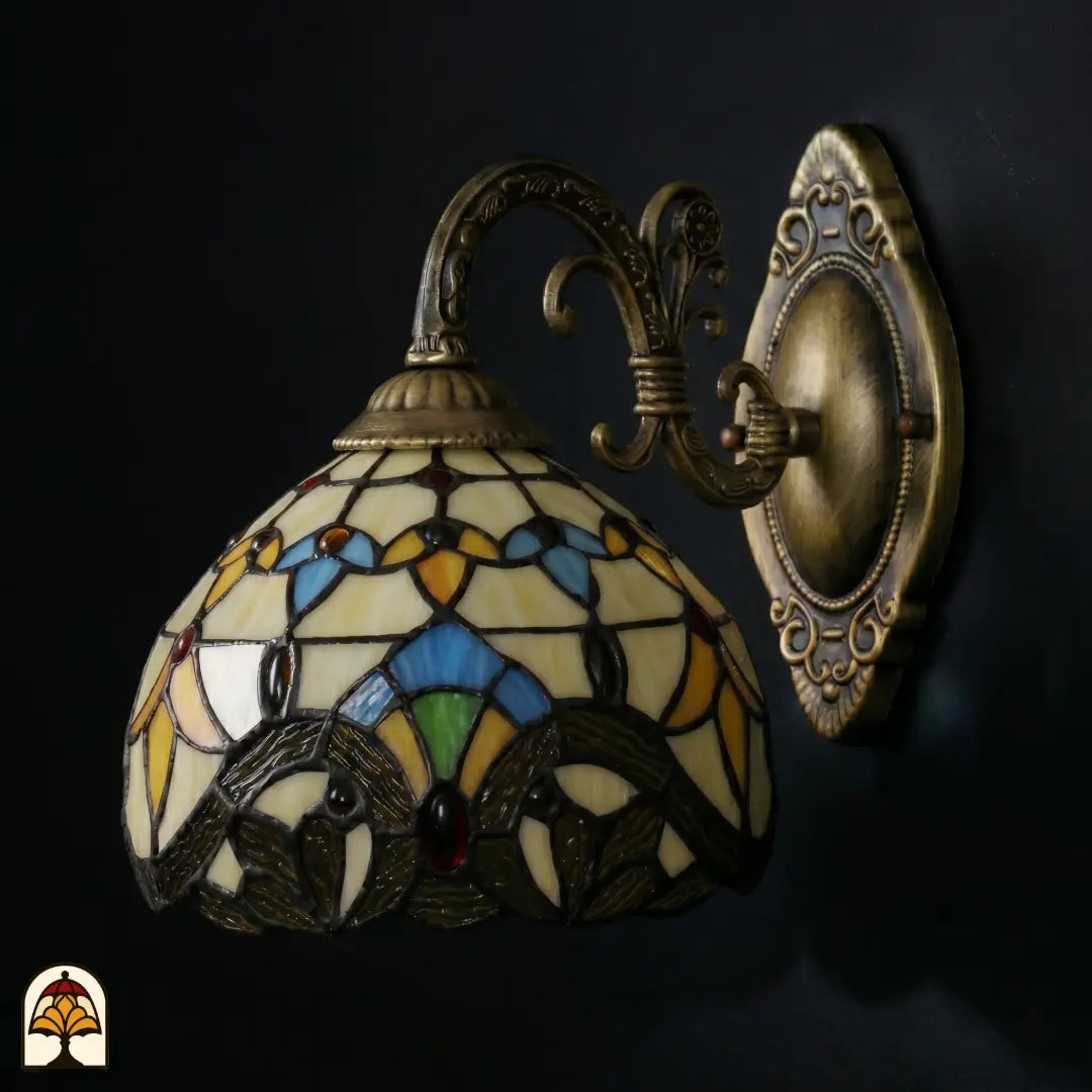 Onverlichte Tiffany wandlamp Barok van opzij met bronzen beugel, kap met barokke glas-in-lood stukken in goudgeel, blauw en rood
