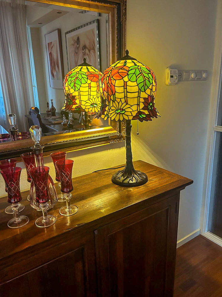 Een handgemaakte Tiffany tafellamp met geometrisch glas in lood patroon op een donkere voet.