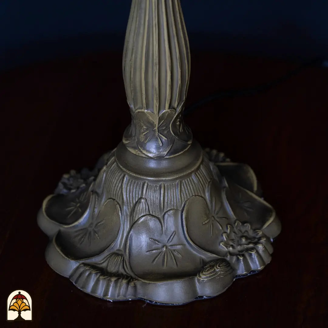 Close-up voet Tiffany tafellamp Frutta Viva — bronzen voet met decoratief vlinder- en bloemenpatroon, geribbelde schacht