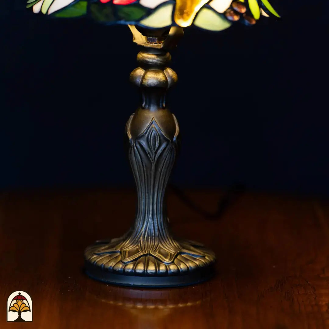Close-up voet — bronzen klassieke kandelaarvoet met bladvormige decoraties en geribbelde ronde basis op houten oppervlak