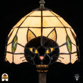 Detail van de glas-in-lood kap met kattengezicht, gouden ogen en groene blaadjes
