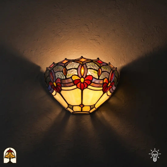 Tiffany wandlamp Giglio Rubino verlicht op muur – halfronde kap met rode bloemen en warme ambertinten