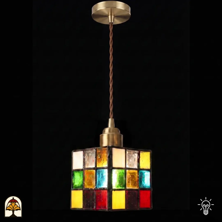 Tiffany hanglamp Cubo Colorato verlicht op zwarte achtergrond – kubusvormige kap met veelkleurige glasvlakken
